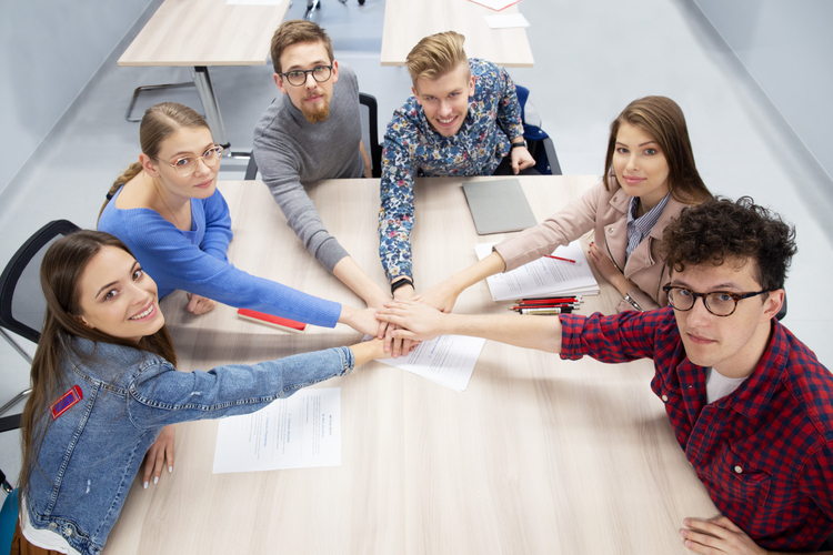 Grupa studentów trzyma się za ręce w znaku jedności