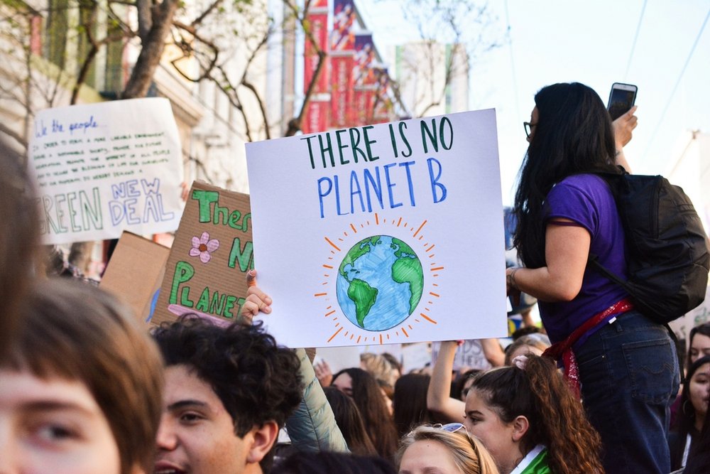 young people protesting and holding a poster "There is no planet B", photo by Li-An Lim on Unsplash